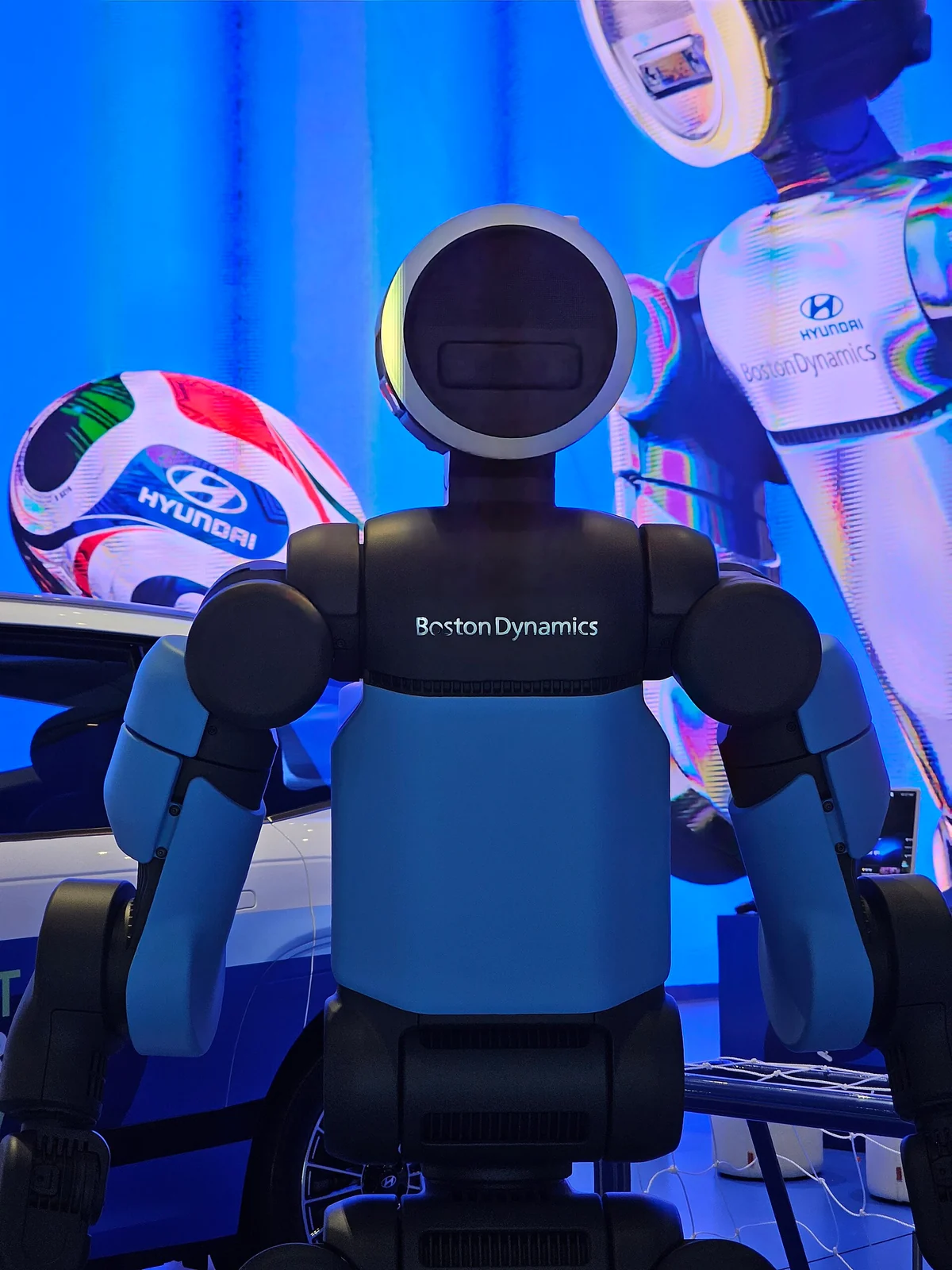 Electric Atlas humanoid upper body with round head display, exhibition photo