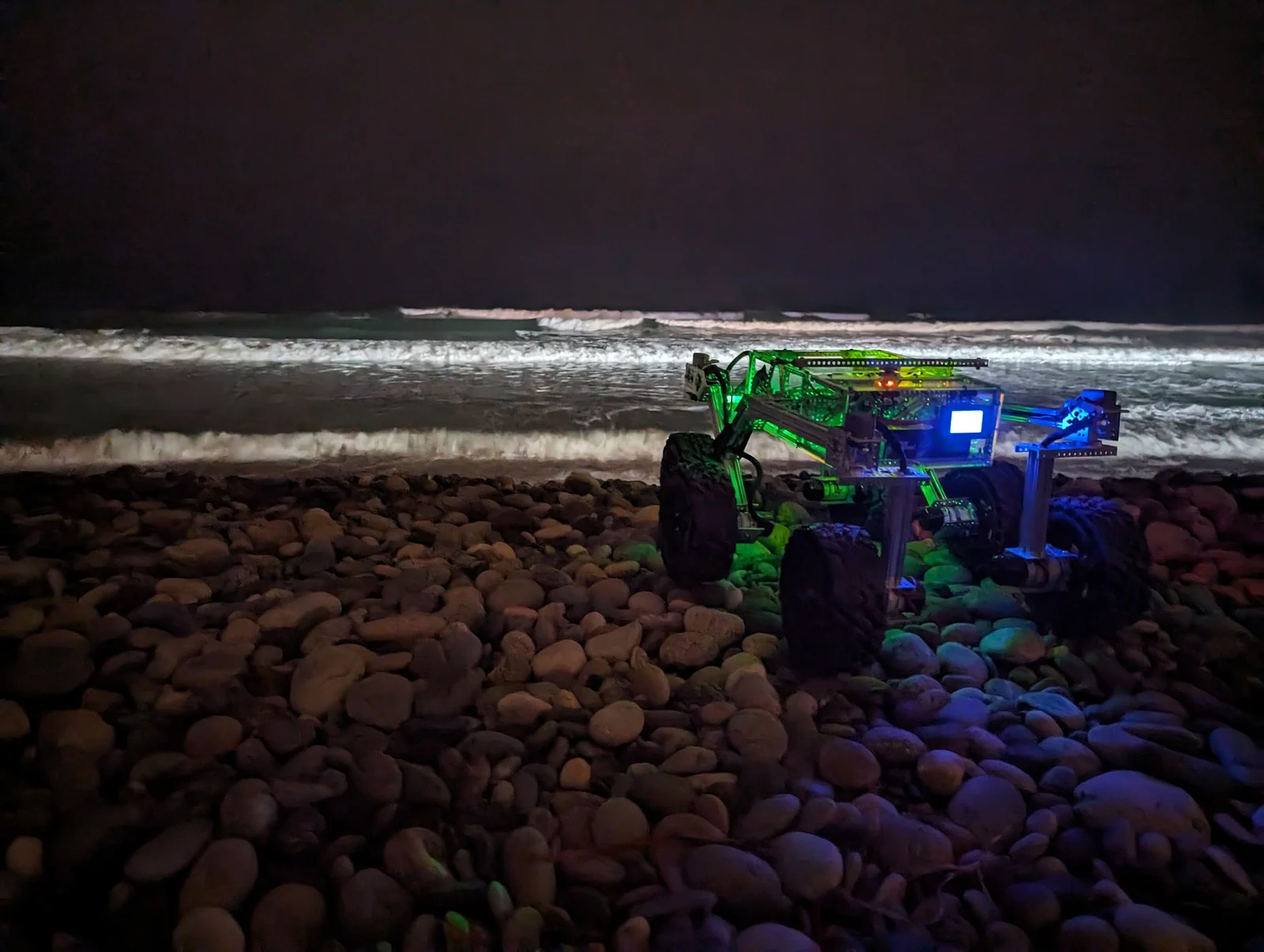 Open Source Rover on a pebble beach at dusk with LED lighting