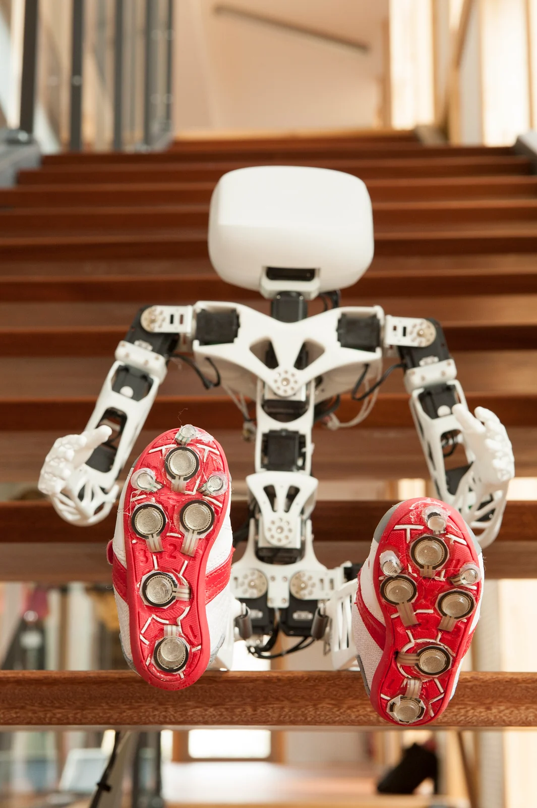 Poppy Humanoid 3D-printed robot sitting on stairs